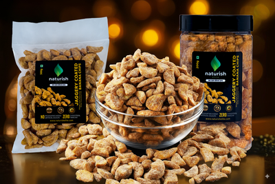 Naturish Elite jaggery-coated banana chips displayed in a glass bowl, stand-up pouch and plastic jar against a warm festive background.