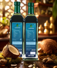 Two Naturish Elite virgin coconut oil bottles showing nutrition labels, with fresh coconut halves on a rustic kitchen counter.