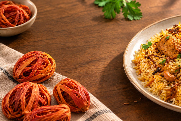 Mace blades beside a pot of Kerala biryani rice